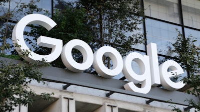 A Google sign hangs over an entrance to the company's new building, Sept. 6, 2023, in New York.