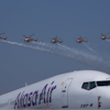 Akasa Air's 737-8 aircraft is seen in foreground as Indian Air Force Sarang helicopters perform an aerobatic display during the 'Wings India 2024,' a biennial aviation event at Begumpet airport in Hyderabad, India, Thursday, Jan. 18, 2024.