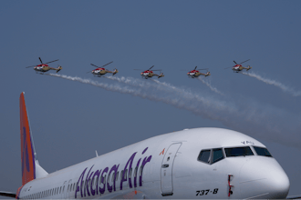 Akasa Air's 737-8 aircraft is seen in foreground as Indian Air Force Sarang helicopters perform an aerobatic display during the 'Wings India 2024,' a biennial aviation event at Begumpet airport in Hyderabad, India, Thursday, Jan. 18, 2024.