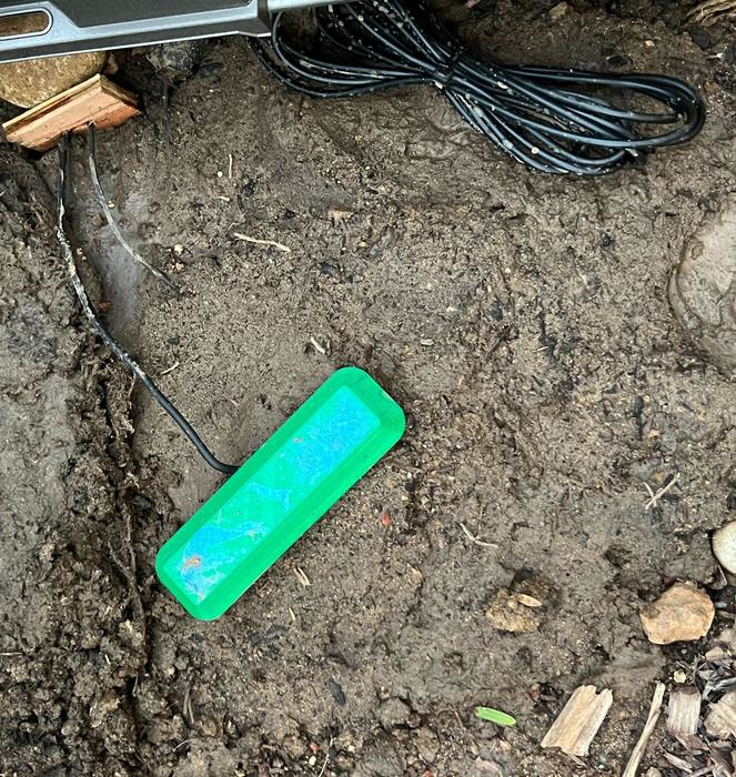 The fuel cell's 3D printed cap peeks above the ground. The cap keeps debris out of the device while enabling air flow.