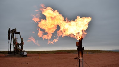 A flare burns natural gas at an oil well Aug. 26, 2021, in Watford City, N.D.
