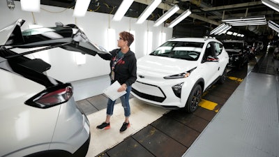 Assembly line worker Janice DeBono looks over a 2023 Chevrolet Bolt EUV at the General Motors Orion Assembly, June 15, 2023, in Lake Orion, Mich.