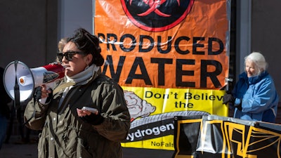 Julia Bernal, with Pueblo Action Alliance, speaks at a protest against an initiative by Gov. Michelle Lujan Grisham to develop a strategic new source of water, buying treated water that is the byproduct of oil and natural gas drilling, then treating it and selling it back to industry.