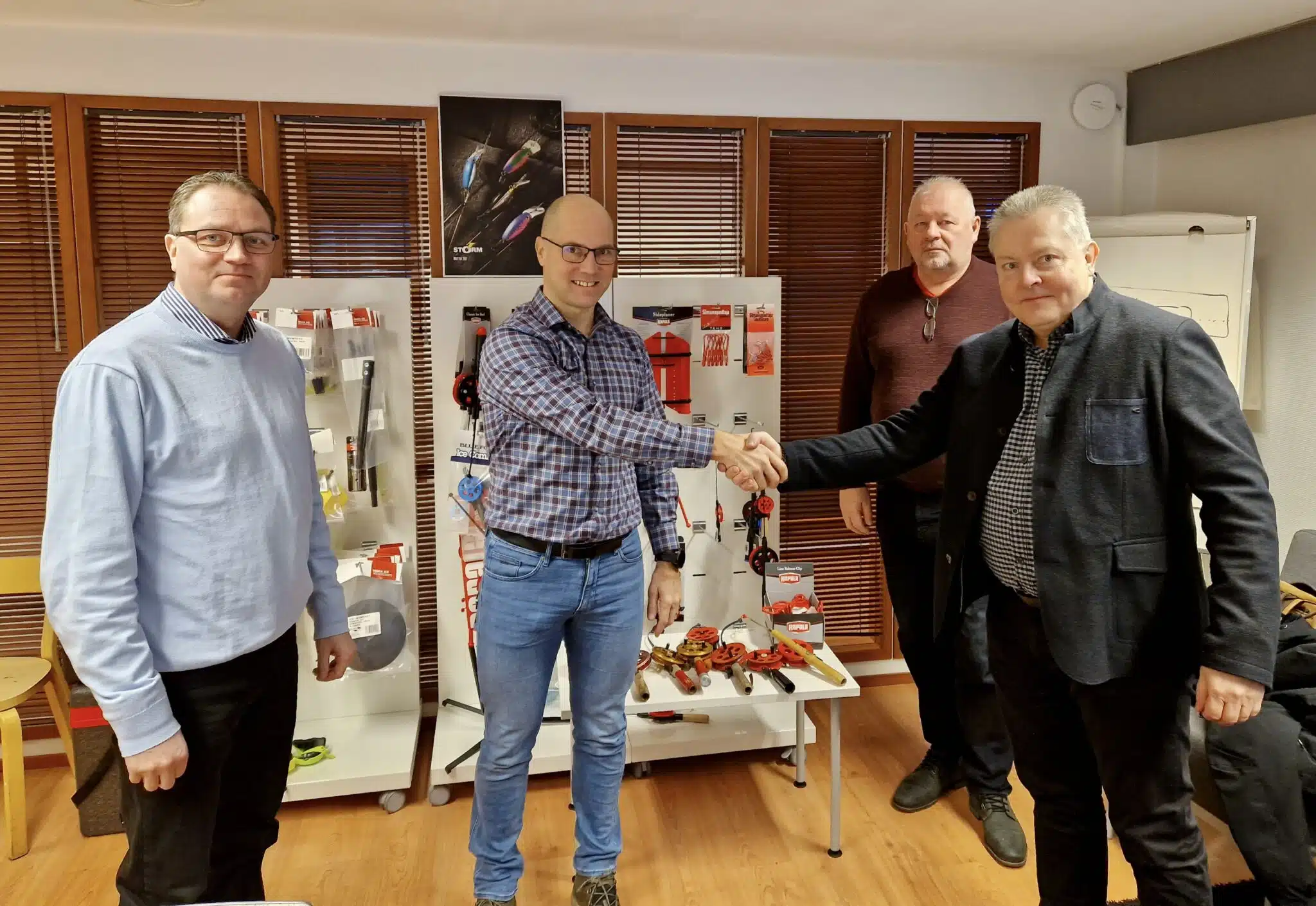 Muottituote CEO Tero Vanninen and Rapala VMC Business Director Arto Nygren shake hands. On the left is Muottituote's Chairman of the Board Jukka Nurmi and in the background Jukka Roikonen, CEO of KL-Teho Oy.