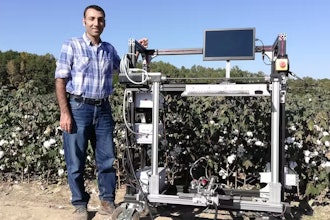 Mississippi State University engineering professor Hussein Gharakhani with a prototype robotic cotton harvester.
