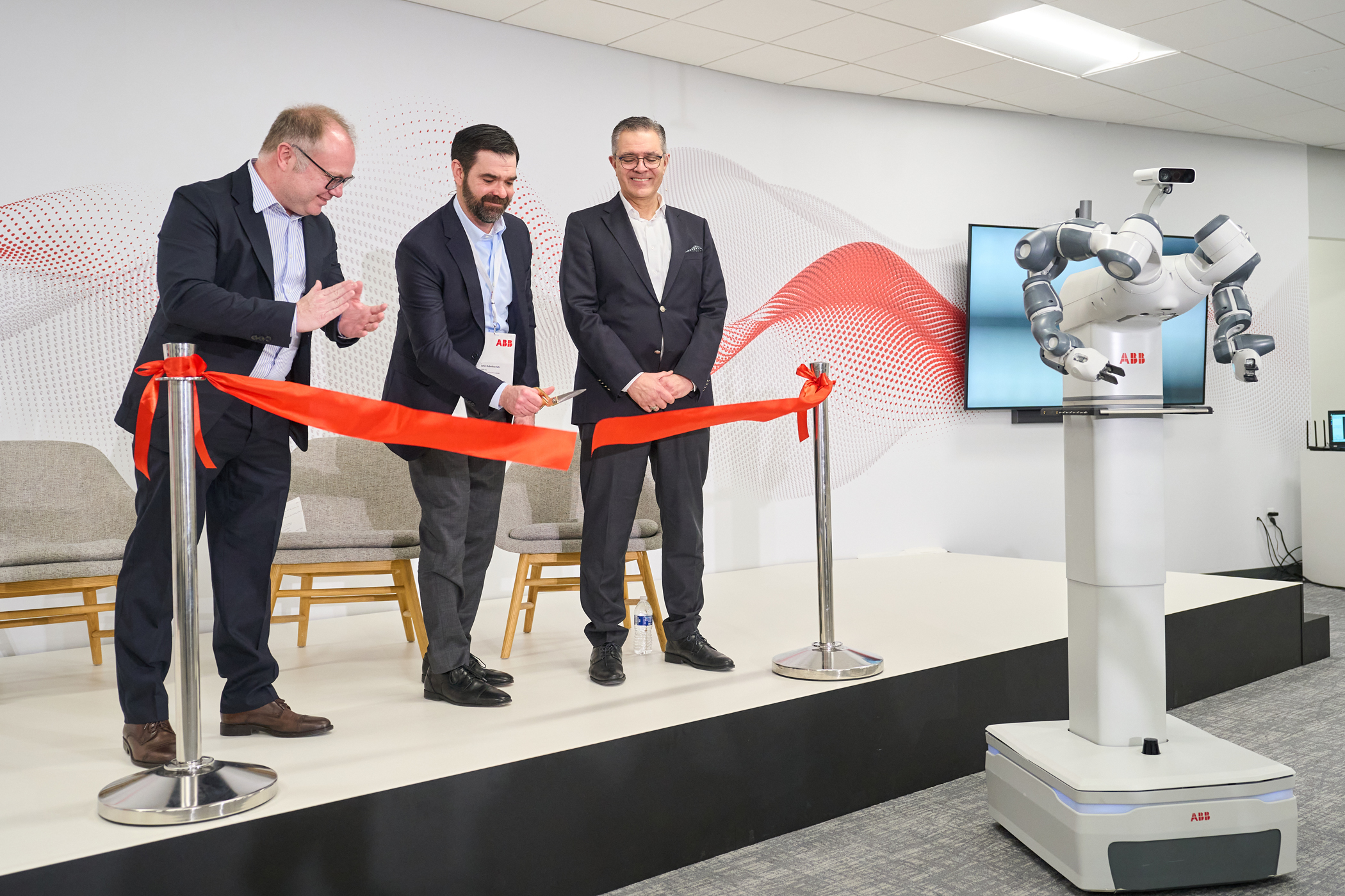 From left, ABB's Marc Segura, John Bubnikovich and Sami Atiya cut the ribbon on ABB Robotics' renovated facility, Auburn Hills, Mich., March 13, 2024.