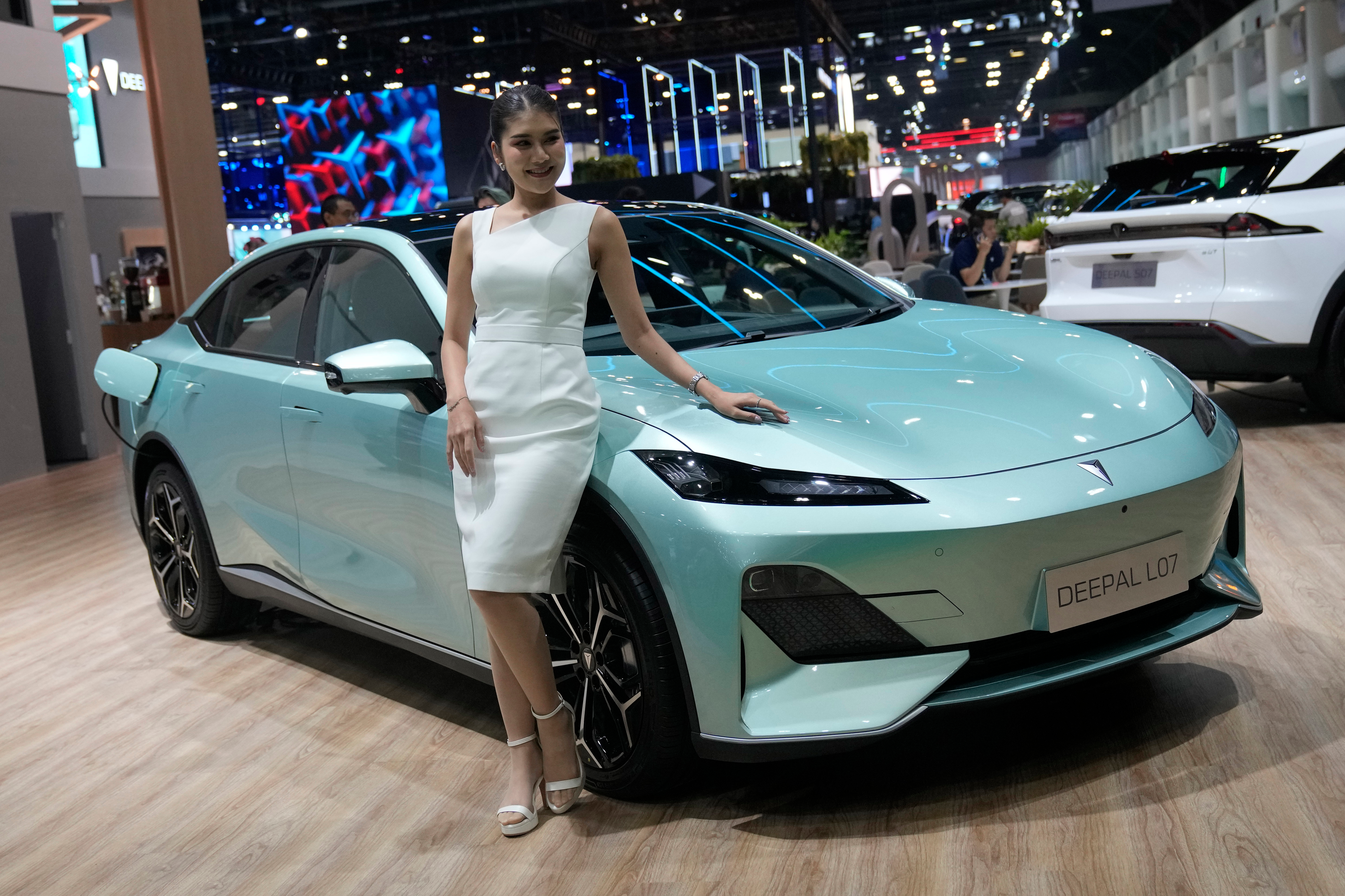 A model stands next to CHANGAN's electric vehicle 'Deepal LO7' during the 45th Bangkok Motor Show in Nonthaburi, Thailand, Tuesday, March 26, 2024.
