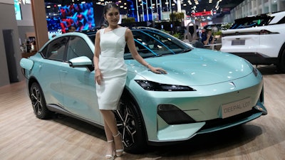 A model stands next to CHANGAN's electric vehicle 'Deepal LO7' during the 45th Bangkok Motor Show in Nonthaburi, Thailand, Tuesday, March 26, 2024.