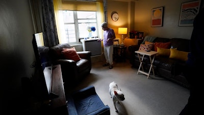 Regina Fred touches one of her window-mounted heat pumps in her apartment in the Queens borough of New York, on Thursday, Feb. 29, 2024.