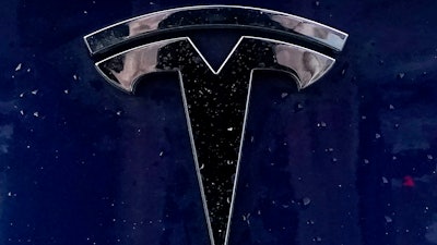 A Tesla electric vehicle emblem is affixed to a passenger vehicle Sunday, Feb. 21, 2021, in Boston.
