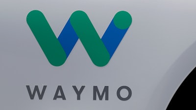 In this May 8, 2018, file photo, a Waymo logo is displayed on the door of a car at the Google I/O conference in Mountain View, Calif.