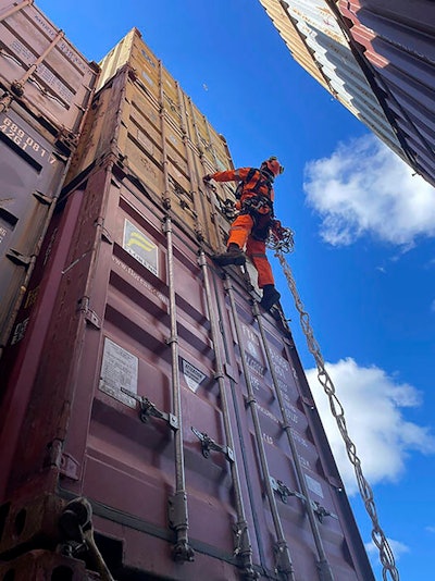 In this photo provided by the Key Bridge Response 2024 Unified Command, a specialized salvage climber scales a container to survey the damage to containers onboard the cargo ship Dali at the site of the Francis Scott Key Bridge, Saturday, April 6, 2024, in Baltimore.