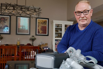 Jeffrey Reed, who experienced persistent sinus infections and two bouts of pneumonia while using a Philips CPAP machine, poses with the device at his home, Oct. 20, 2022, in Marysville, Ohio.