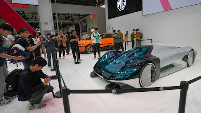 Visitors take photos of a MG concept car during an opening of China Auto Show in Beijing, China, Thursday, April 25, 2024.