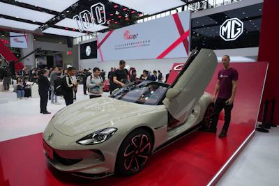 Visitors look at an MG car during the opening of China Auto Show in Beijing, China, Thursday, April 25, 2024.