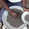 A Congolese miner sifts through ground rocks to separate out the cassiterite, the main ore that's processed into tin, in the town of Nyabibwe, eastern Congo, Aug. 16, 2012.