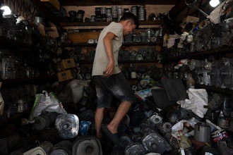 Tu Chi Vy tiptoes through his shop packed with refurbished motors in Nhat Tao Market, the largest informal recycling market in Ho Chi Minh City, Vietnam, on Monday, Jan. 29, 2024.
