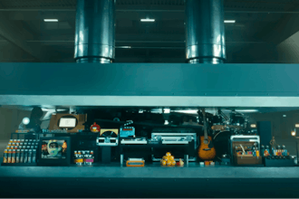 In this image taken from a video advertisement, a hydraulic press crushes an array of creative instruments.