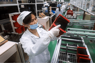 A worker checks solar panels at a factory in Jiujiang in central China's Jiangxi province on March 16, 2018.