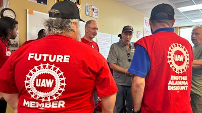 UAW President Shawn Fain, center, speaks with Mercedes workers in Tuscaloosa, Alabama on May 17, 2024 after workers at two Alabama Mercedes-Benz factories voted overwhelmingly against joining the United Auto Workers union.