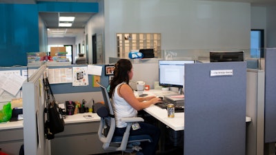 Social worker Lupita Armijo-Garcia works at her desk in the Ottawa County, Mich., Department of Public Health office, Sept. 5, 2023, in Holland, Mich. On Friday, May 3, 2024, the U.S. government issues its April jobs report.