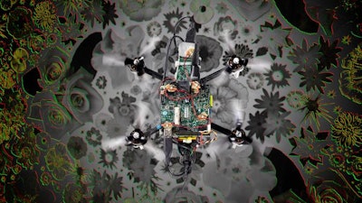 Photo of the “neuromorphic drone” flying over a flower pattern. It illustrates the visual inputs the drone receives from the neuromorphic camera in the corners. Red indicates pixels getting darker, green indicates pixels getting brighter.