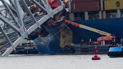 Workers remove wreckage of the collapsed Francis Scott Key Bridge, Thursday, April 25, 2024, in Baltimore.