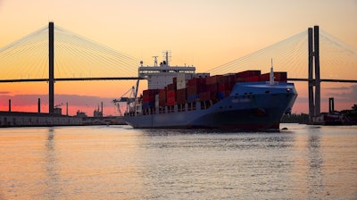 A commercial cargo ship as it leaves the Port of Savannah in Georgia at sunset.