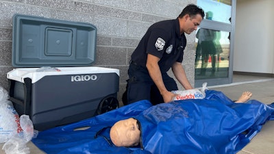 Phoenix Fire Capt. John Prato demonstrates a new protocol that the fire department in America’s hottest big city is adopting as the West braces for the first heat wave of the summer season, Monday, June 3, 2024, in Phoenix. The cold water immersion therapy already used by hospitals in the area will also now be used by Phoenix fire and paramedics personnel on every patient they encounter this season with signs of heat stroke.