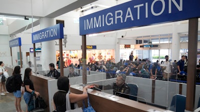 Officers check the passports of passengers leaving for Singapore at the immigration checkpoint of the Bandar Bentan Telani ferry terminal on Bintan Island, Indonesia.