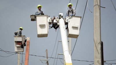 Puerto Rico Electric Power Authority workers repair distribution lines damaged by Hurricane Maria in the Cantera community of San Juan, Puerto Rico.