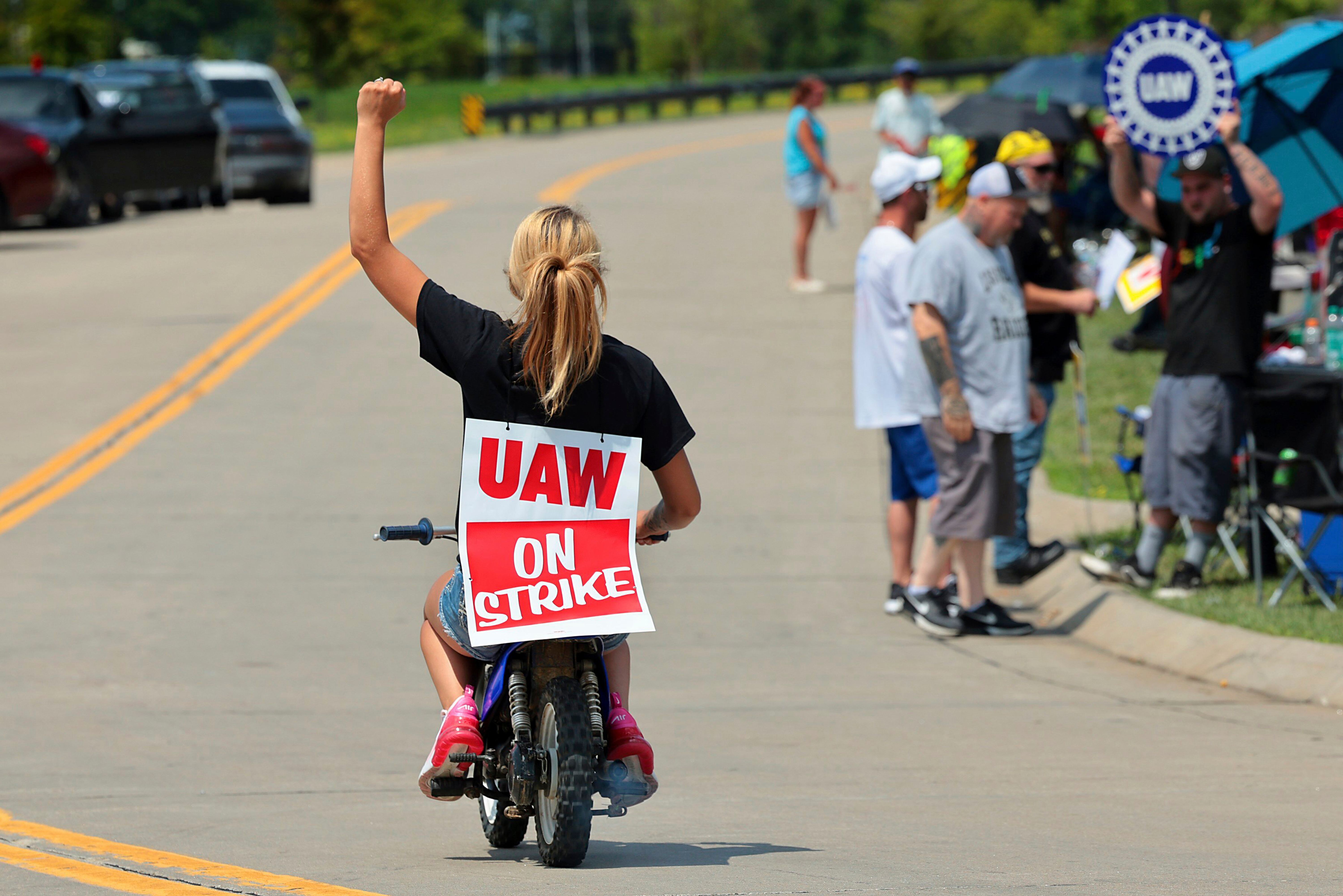 Lear production worker Abigail Fletcher rides her mini bike in support of the picket line as members of United Auto Workers Local 282 continue their strike against the car and truck seat manufacturer in Wentzville, Mo. on Tuesday, July 23, 2024.