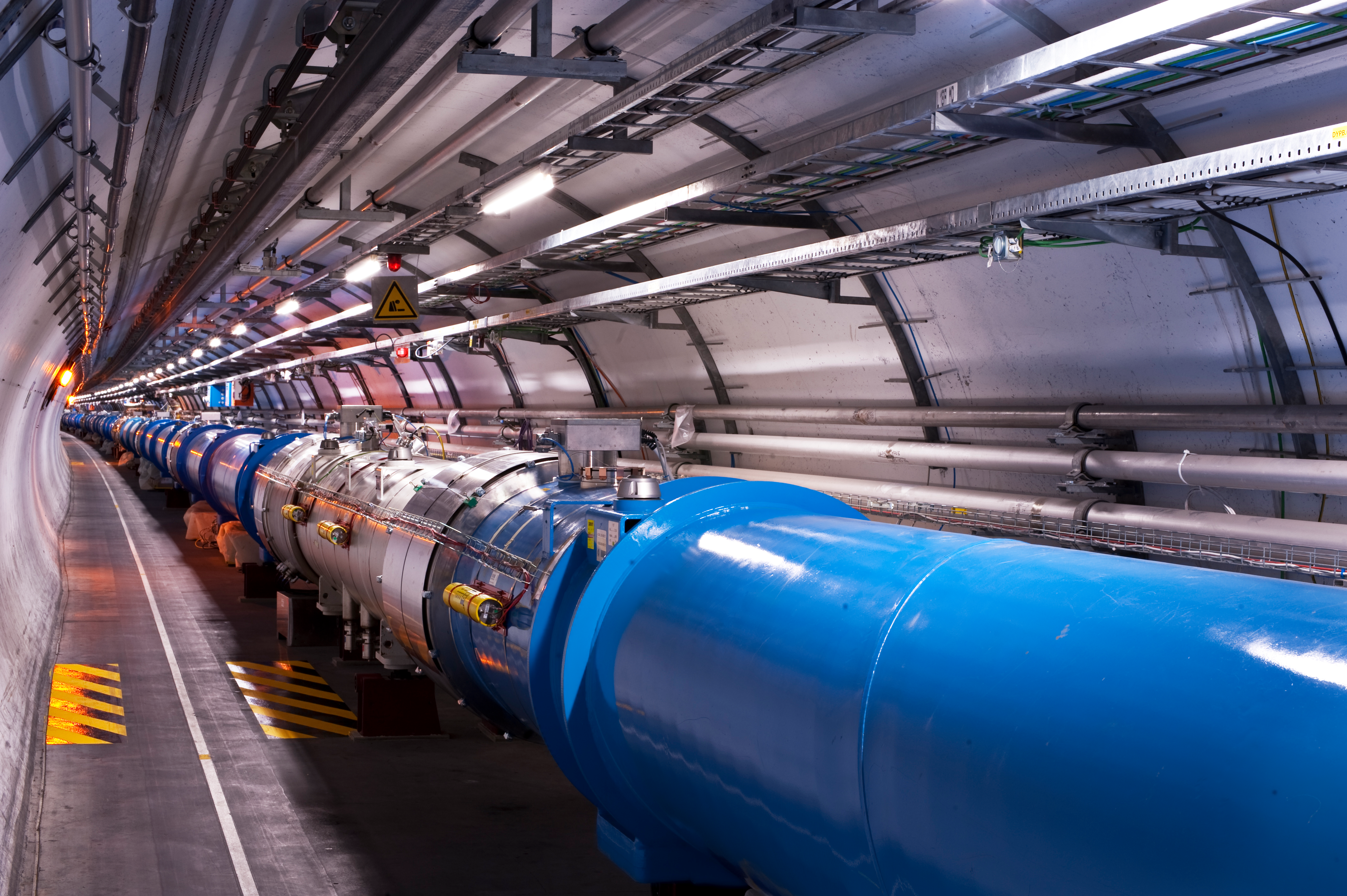 Particles rush through a long tunnel in the Large Hadron Collider.