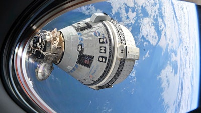 This photo provided by NASA shows Boeing's Starliner spacecraft which launched astronauts Butch Wilmore and Suni Williams to the International Space Station docked to the Harmony module's forward port on July 3, 2024, seen from a window on the SpaceX Dragon Endeavour spacecraft docked to the adjacent port.