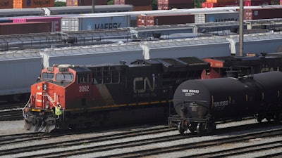 Employees are seen on a locomotive being moved at the Canadian Pacific Kansas City (CPKC) rail yard in Port Coquitlam, British Columbia, Monday, Aug. 19, 2024.