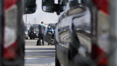 Amazon drivers wait next to their delivery vans after logistics systems went offline at the Amazon Delivery Station in Rosemead, Calif., Dec. 7, 2021.