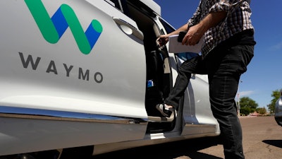 A Waymo minivan arrives to pick up passengers for an autonomous vehicle ride, Wednesday, April 7, 2021, in Mesa, Ariz.
