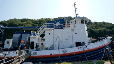 A worker stands near the NH3 Kraken, a tugboat powered by ammonia, on Friday, Sept. 13, 2024, in Kingston, N.Y.