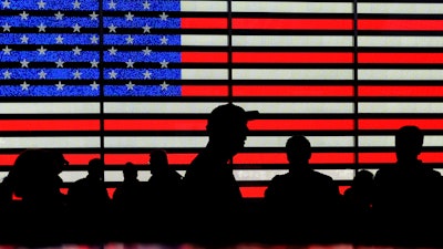 People gather near an electronic display of an American flag in Times Square in New York on Aug. 9, 2024.