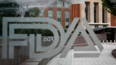 A U.S. Food and Drug Administration building is seen behind FDA logos at a bus stop on the agency's campus in Silver Spring, Md., on Aug. 2, 2018.