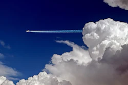Contrail stream following a distant passenger jet.