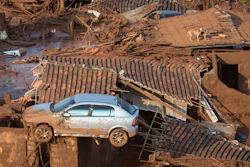 A car and two dogs are on the roof of destroyed houses at the small town of Bento Rodrigues after a dam burst in Minas Gerais state, Brazil, Nov. 6, 2015.