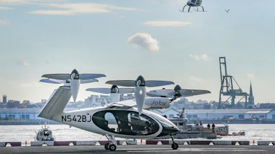 An electric vertical takeoff and landing (eVTOL) aircraft, flies above the Joby eVTOL aircraft, during a demonstration of eVTOLs Nov. 13, 2023, in New York.