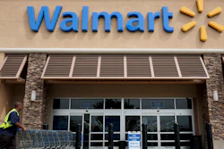 In this May 9, 2013, file photo, a worker pushes shopping carts in front of a Wal-Mart store in La Habra, Calif.