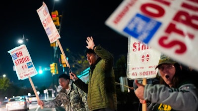 Boeing employees, including assembler Tyrone Hipolito, center, work the picket line after union members voted to reject a new contract offer from the company, Wednesday, Oct. 23, 2024, in Renton, Wash.
