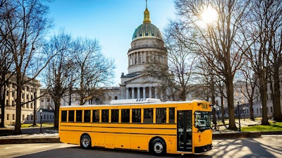 A GreenPower school bus parked in front of the West Virginia State Capitol.
