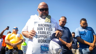 Longshoremen bow for a prayer during a strike at the Bayport Container Terminal on Tuesday, Oct. 1, 2024, in Houston.