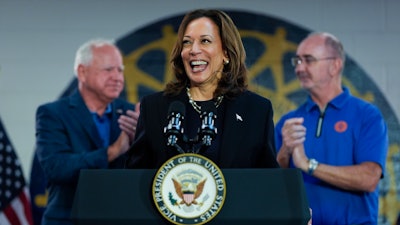 Democratic presidential nominee Vice President Kamala Harris, with Democratic vice presidential nominee Minnesota Gov. Tim Walz, left, and UAW President Shawn Fain, speaks at a campaign rally at UAW Local 900, Aug. 8, 2024, in Wayne, Mich.