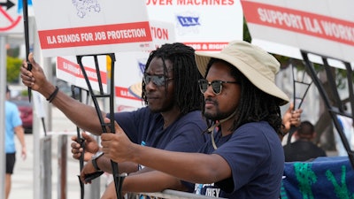 Dockworkers from Port Miami display signs at a picket line, Oct. 3, 2024.