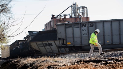 A Norfolk Southern worker walks next to the scene of a multi-car coal train derailment near Suffolk, Va., on Feb. 4, 2017.